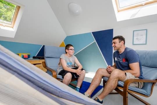 Ein Betreuer im Gespräch mit einem Jungen