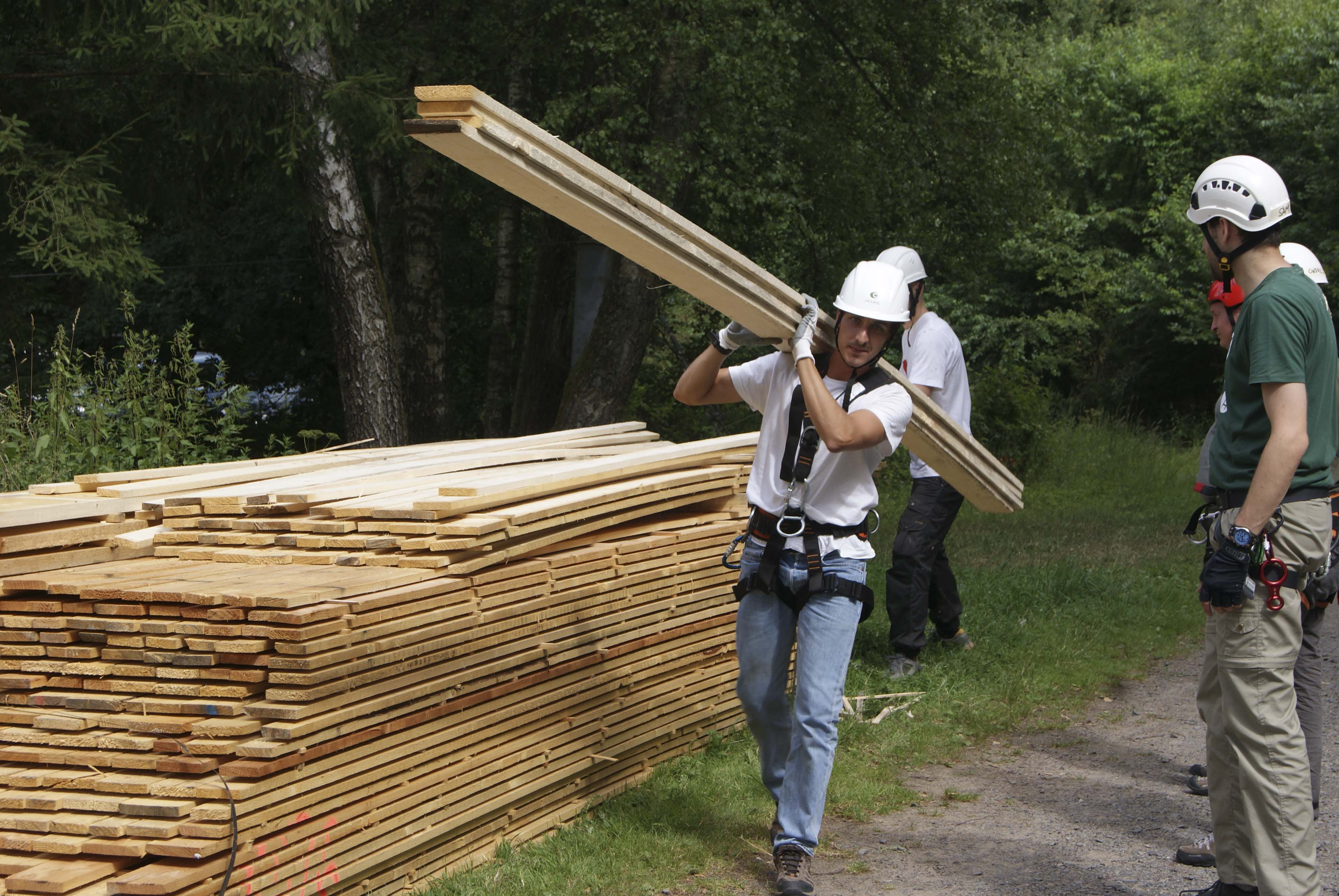 die angelieferten Planken werden zum Baumhaus getragen