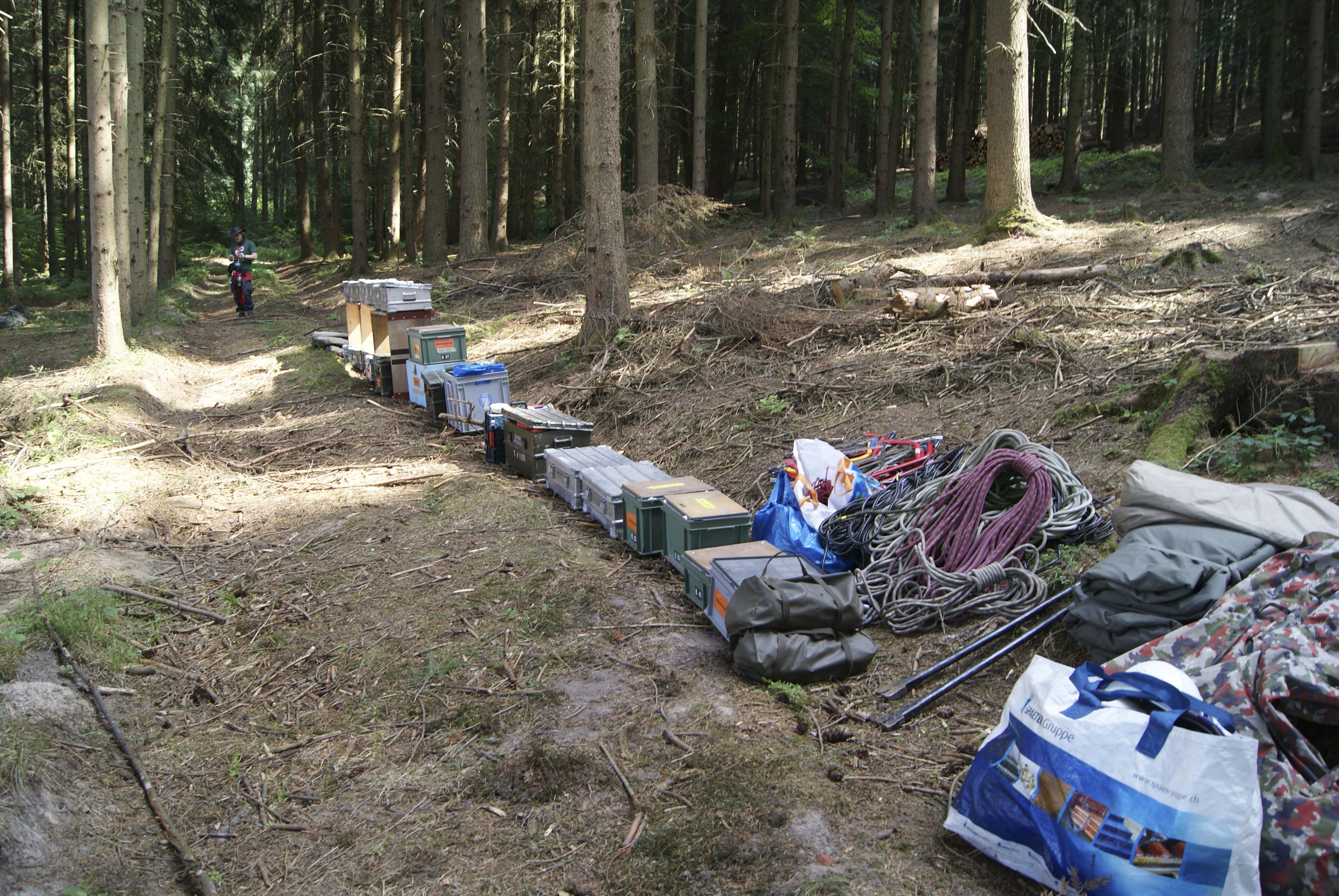 eine lange Reihe mit Materialkisten mitten im Wald