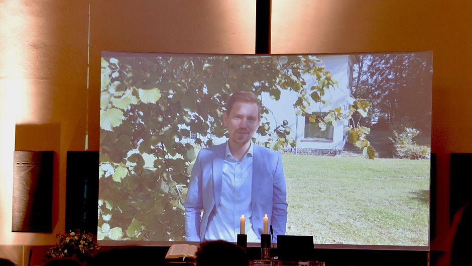 Da die Teilnehmerzahl auch in der Christuskirche beschränkt war, begrüßte der Großteil der Dozierenden die neuen Ersties per Videobotschaft. Auf der Leinwand zu sehen: Prorektor Prof. Dr. Germo Zimmermann