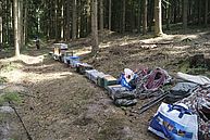 eine lange Reihe mit Materialkisten mitten im Wald